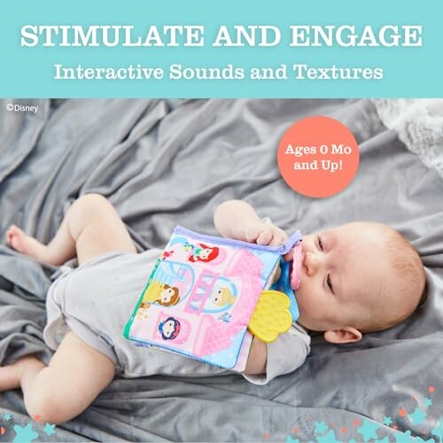 Baby lying on bed with interactive sound and texture toy.