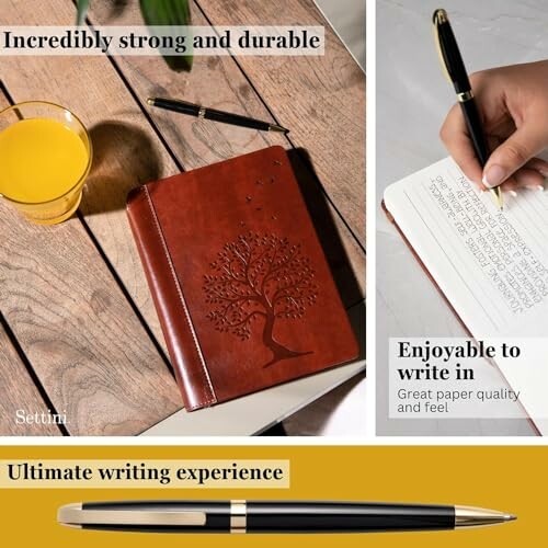 Leather journal with embossed tree design, pen, and glass of juice on table.