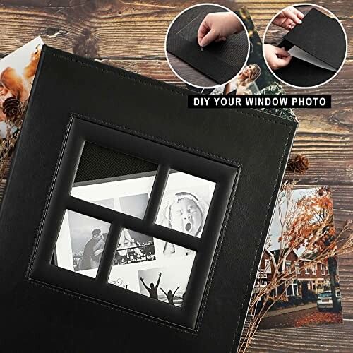 Black photo album with window frame, photos on wooden table.