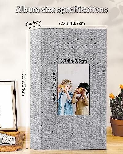 Photo album with size specifications and children holding cameras.